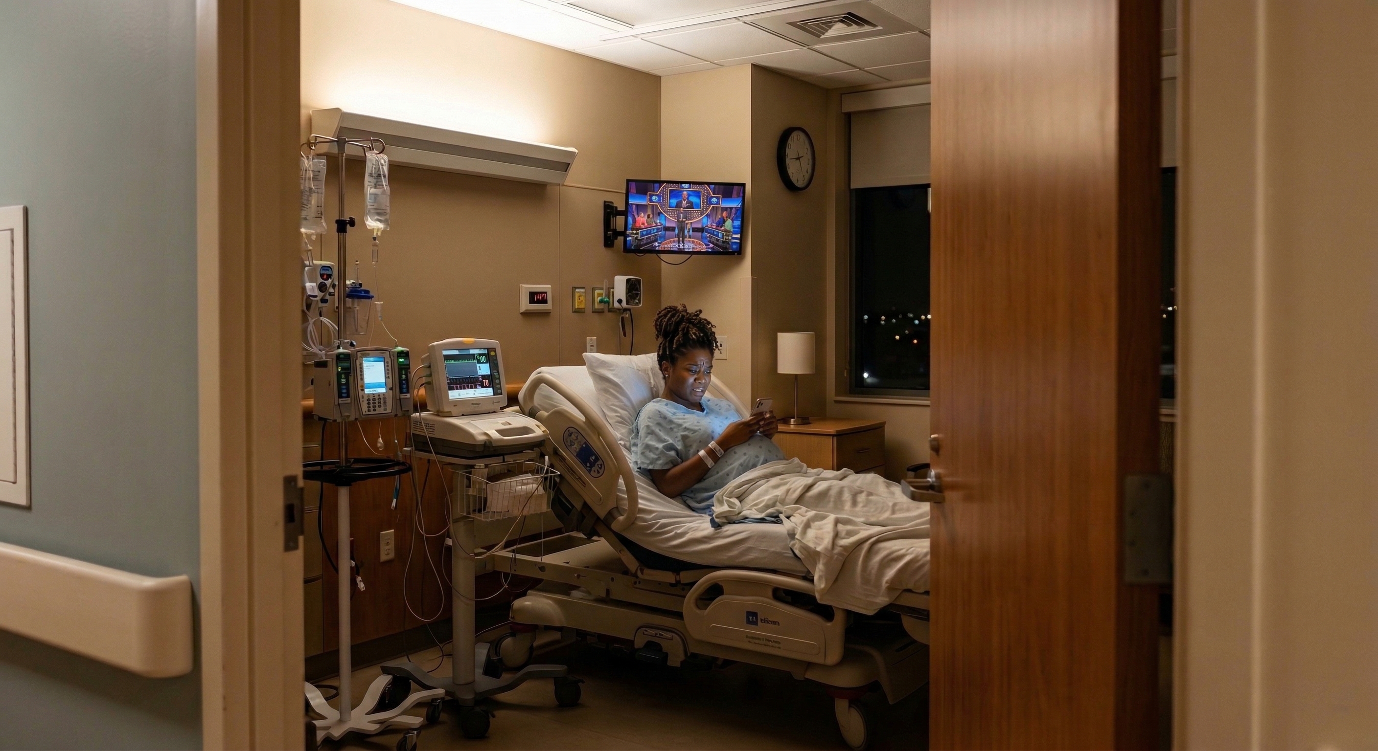 Patient alone in a hospital labor and delivery room, looking at a smartphone with a worried expression